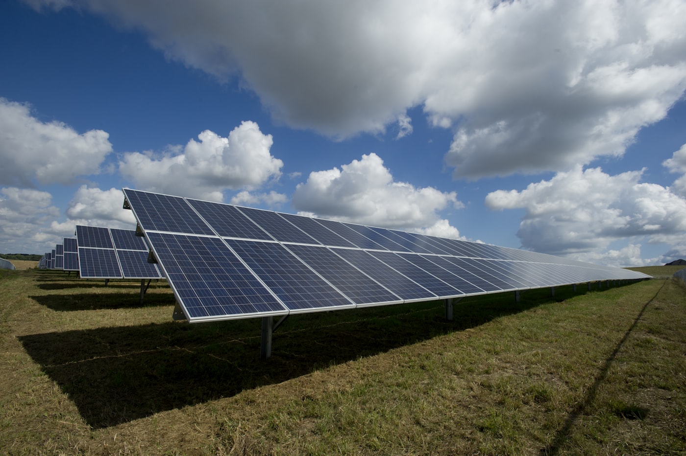 Solar farm in a green field under a blue sky